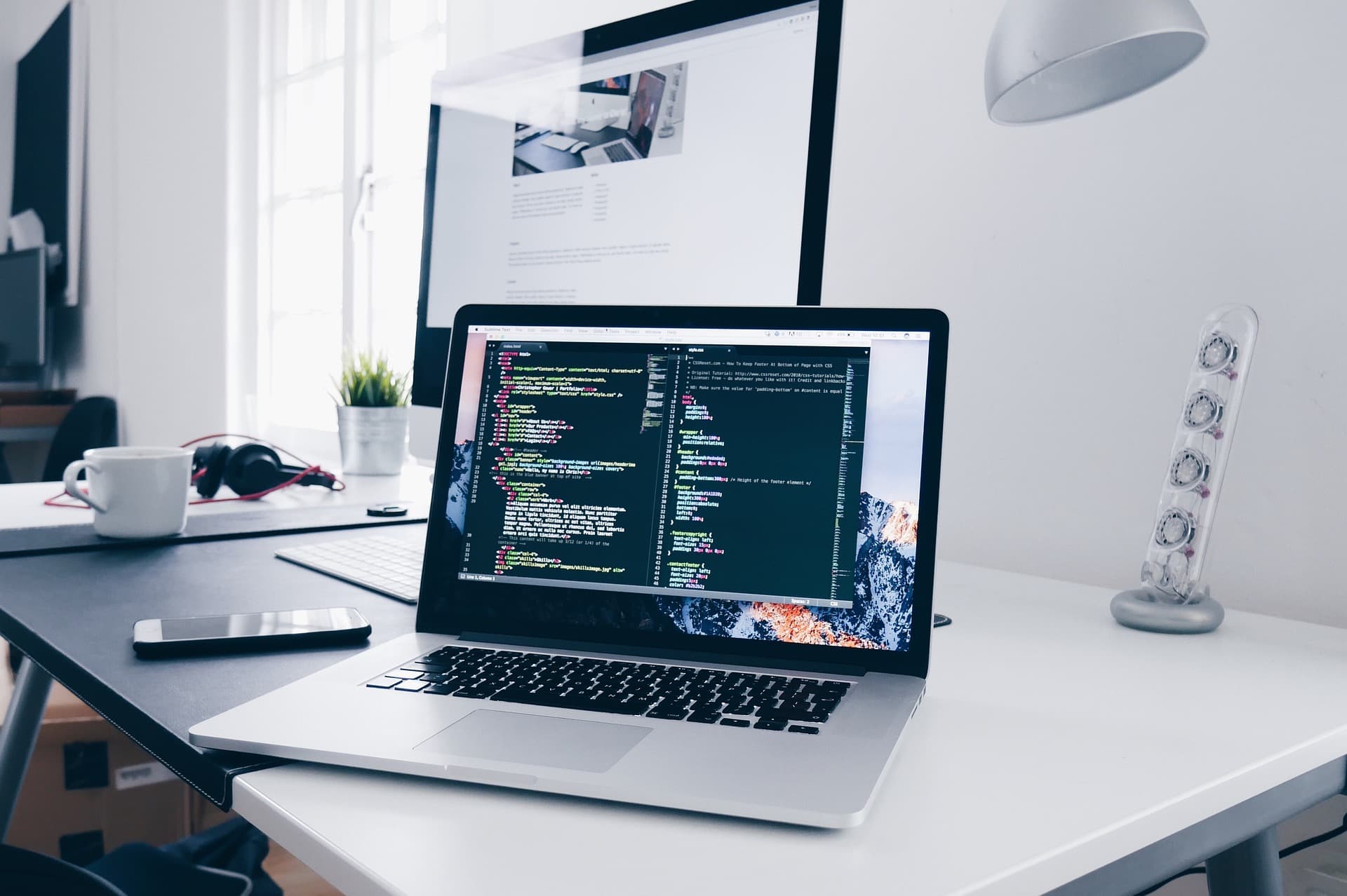 Entwickler-Arbeitsplatz mit Quellcode auf zwei Bildschirmen